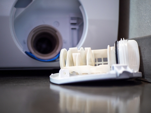 How do I clean the drain blockage in my washing machine